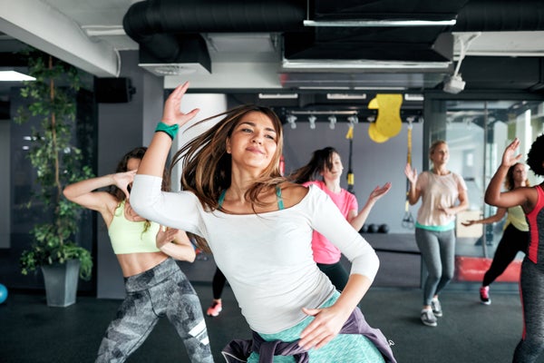 Group of women enjoying fitness dance together in gym.